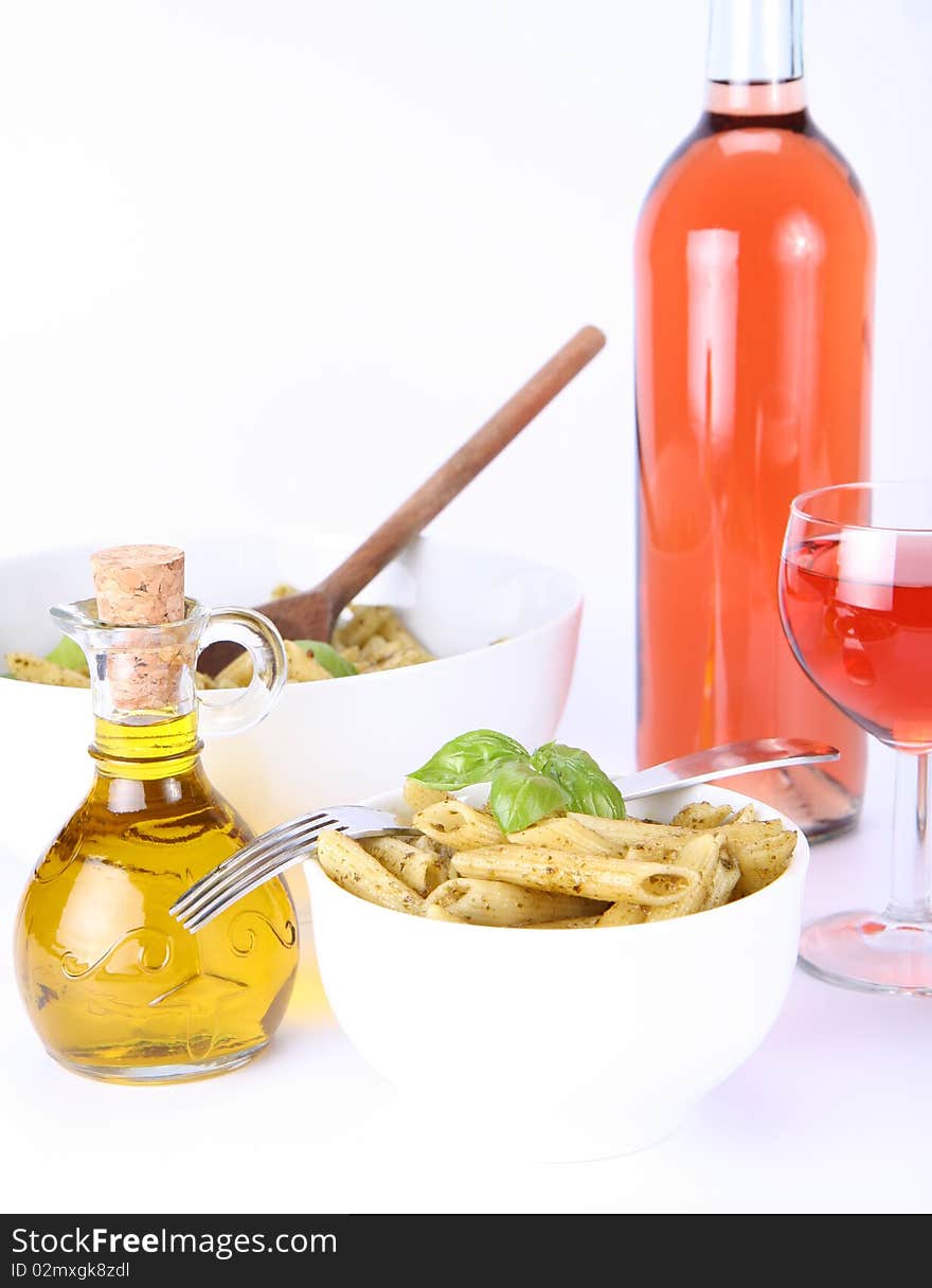 Penne with pesto, bottle of olive oil and pink wine. Penne with pesto, bottle of olive oil and pink wine