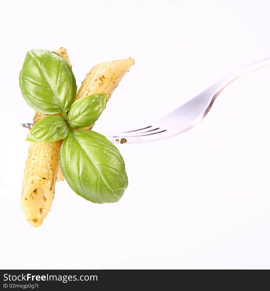 Penne with pesto on a fork