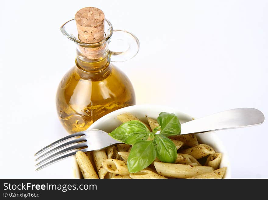 Penne with pesto in  a bowl and olive oil in a bottle. Penne with pesto in  a bowl and olive oil in a bottle