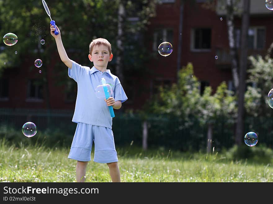 Boy is played with soap bubbles in the street