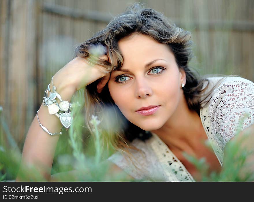 Young pretty summer woman lying in the grass