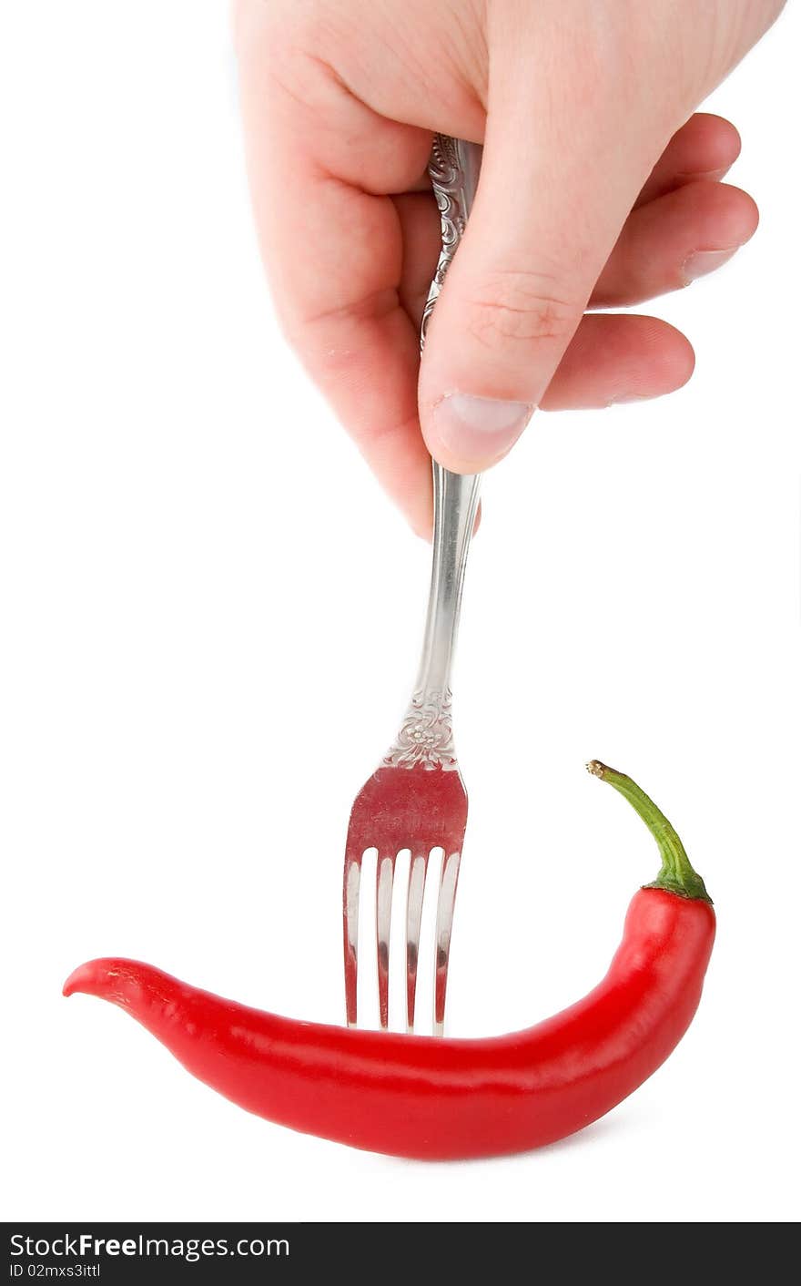 Chili peper in fork with hand