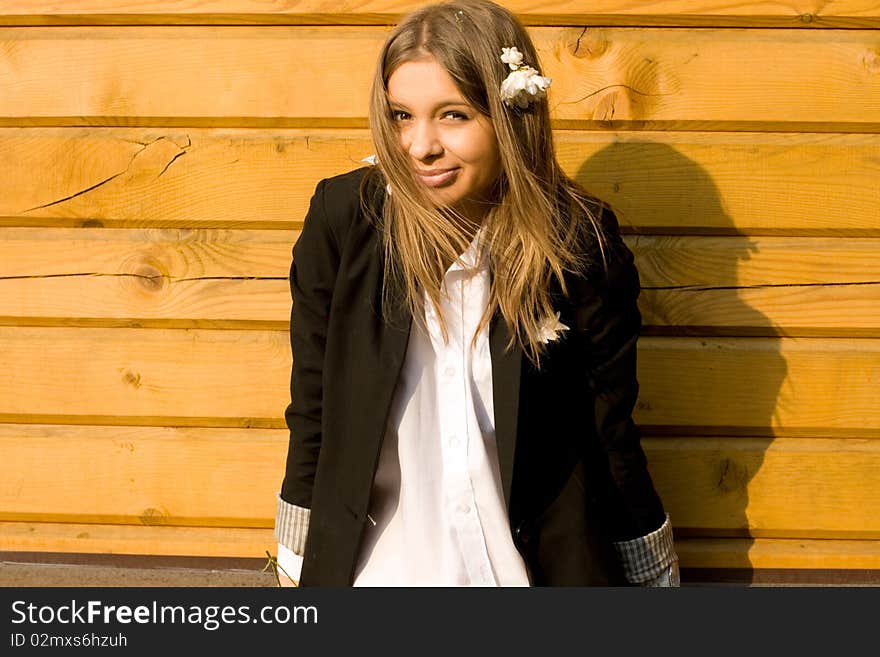 Girl standing in front of a wooden house