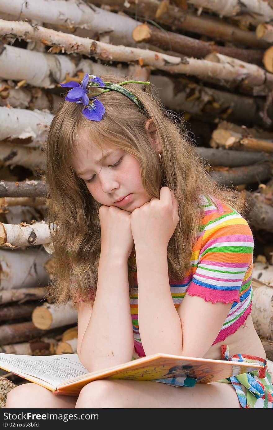 The girl with the dismissed chestnut hair reads the book. The girl with the dismissed chestnut hair reads the book