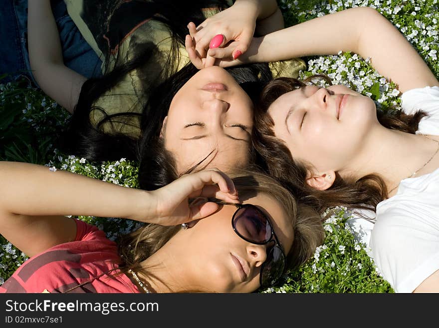 Three girls lying on grass