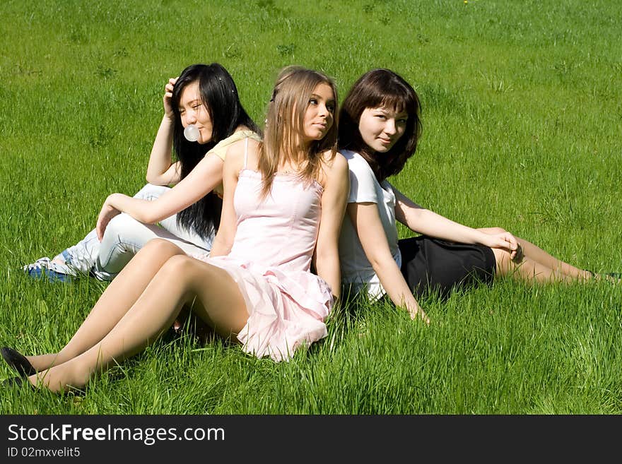 Three girls sitting on grass