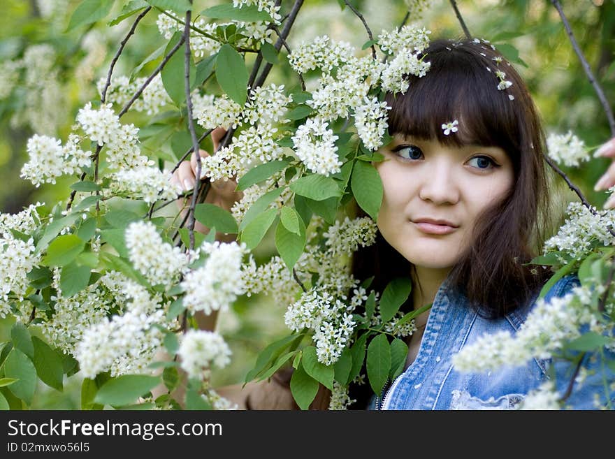 Girl standing near lilac in blossom