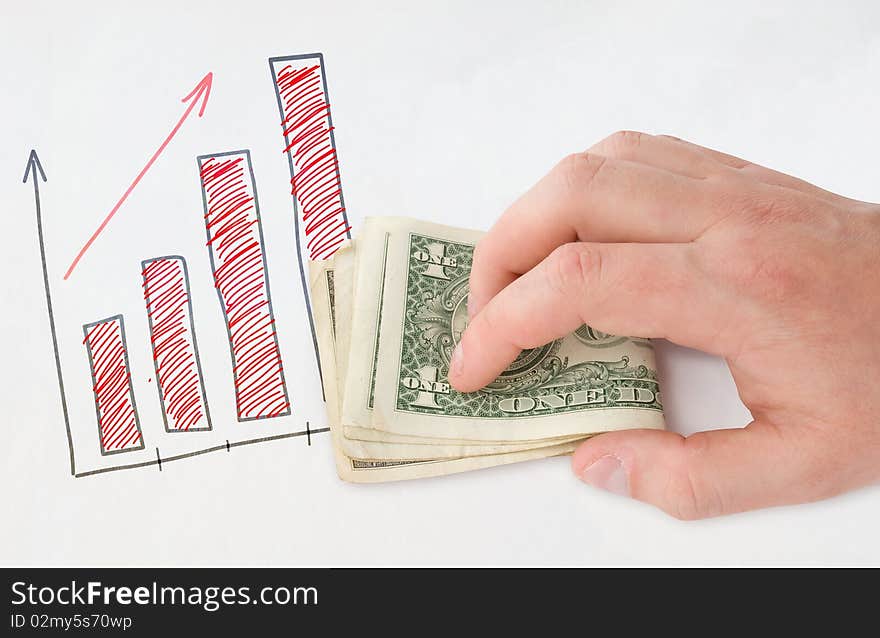 Holding money in hand near drawing graph