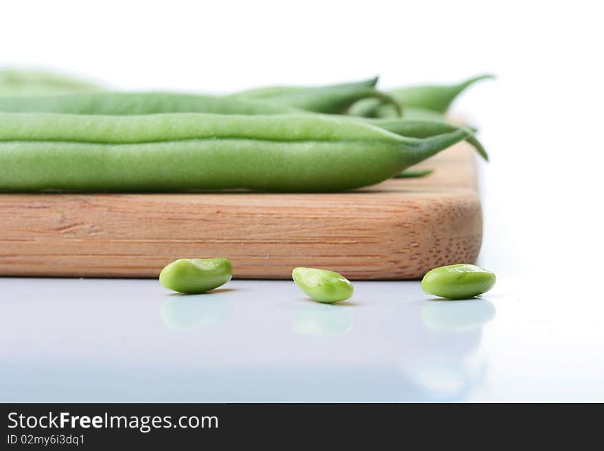 Vegetable kidney bean beans against on a kitchen board.