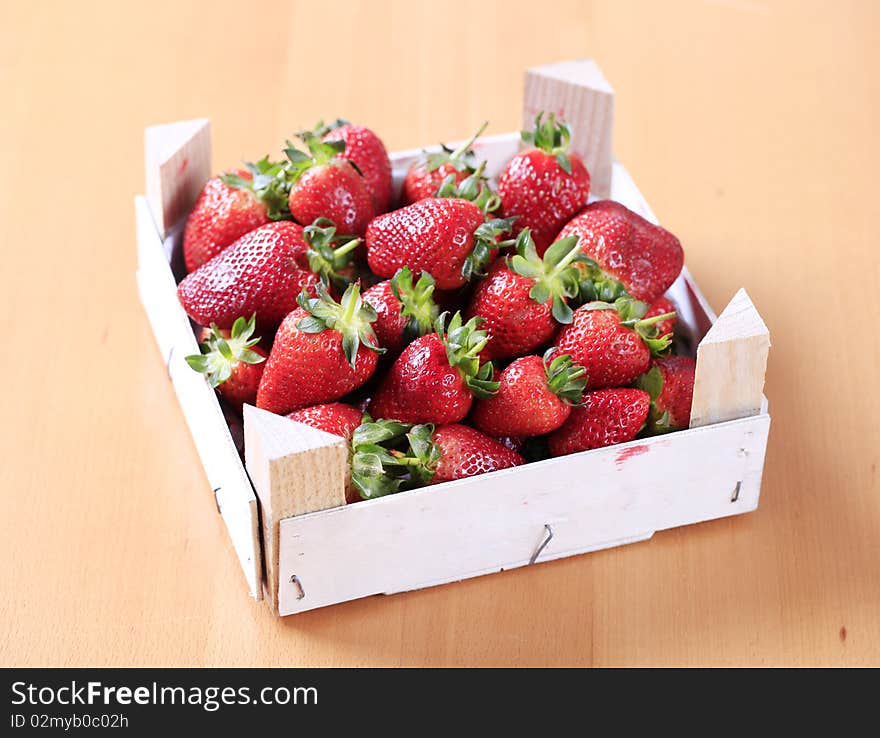 Fresh strawberries in a wooden crate - closeup