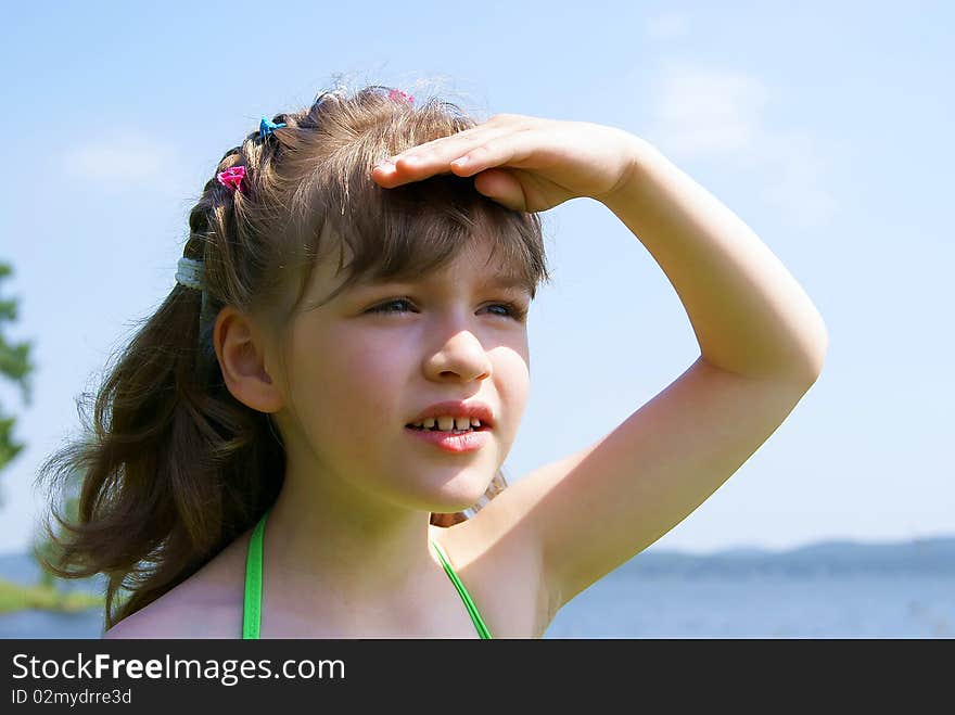 The beautiful girl on the nature looks in the summer afar having taken a hand to a head. The beautiful girl on the nature looks in the summer afar having taken a hand to a head