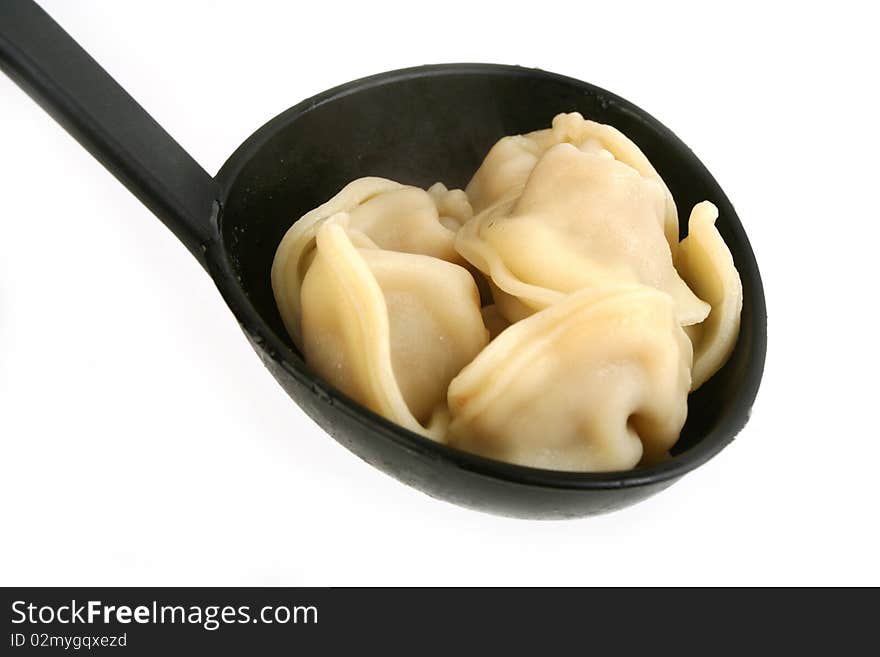 Ravioli in ladle  close-up on white background