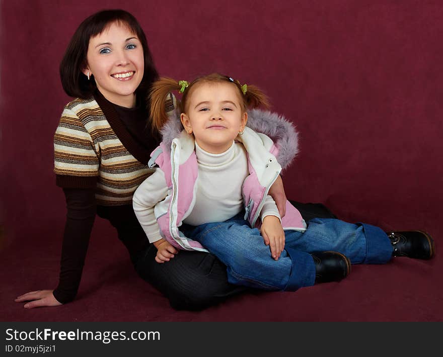 Happy mother with little daughter on red background