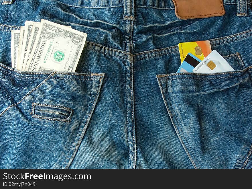 Money and credit cards in two jeans back pocket