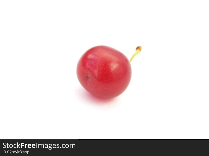 A single ripe cherry with a stem isolated on white background. A single ripe cherry with a stem isolated on white background