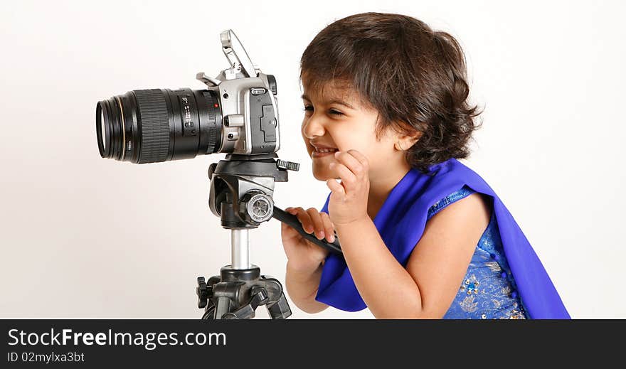 Sweet and pretty toddler playing with camera and taking picture.