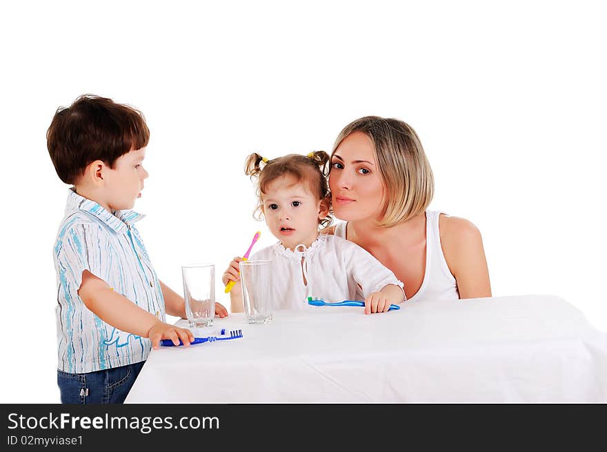 Young mother and her young daughter and son brushing teeth on a white background. Young mother and her young daughter and son brushing teeth on a white background