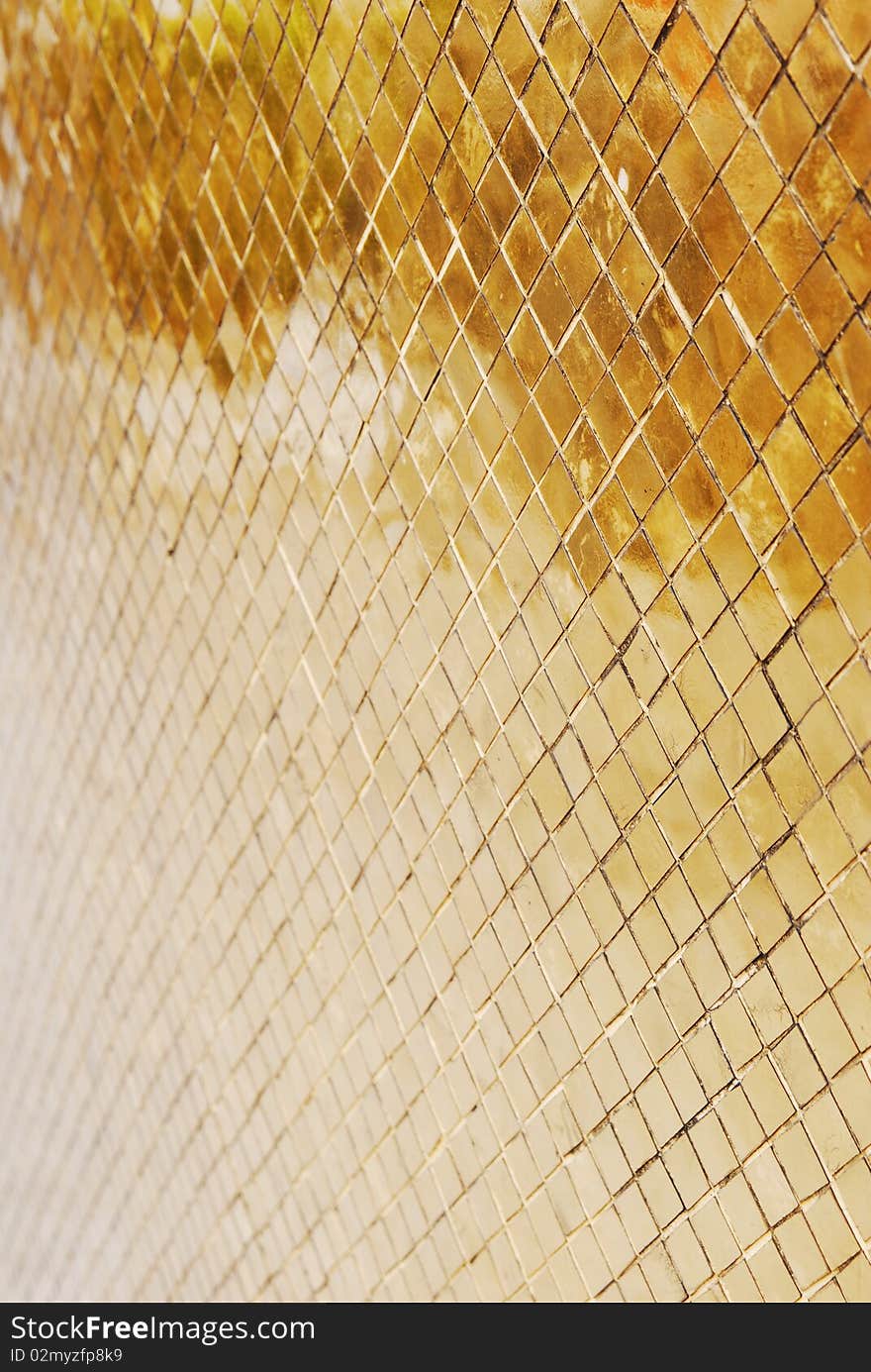 Close up photo of surface covered with tiny golden tiles. Close up photo of surface covered with tiny golden tiles