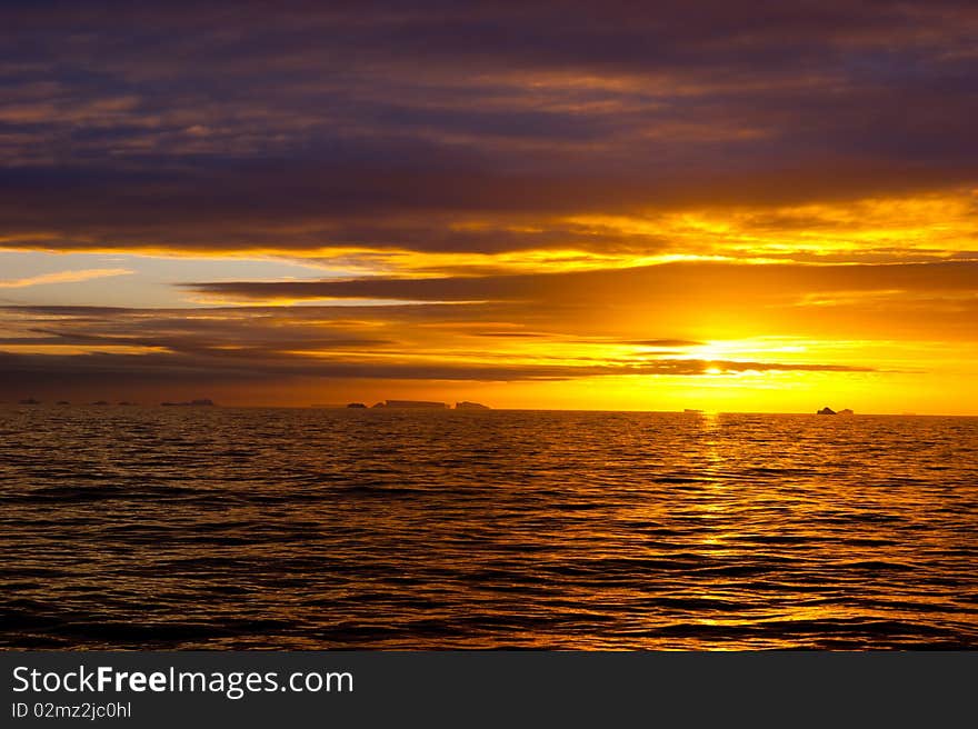 Sunset in atlantic ocean with icebergs. Sunset in atlantic ocean with icebergs