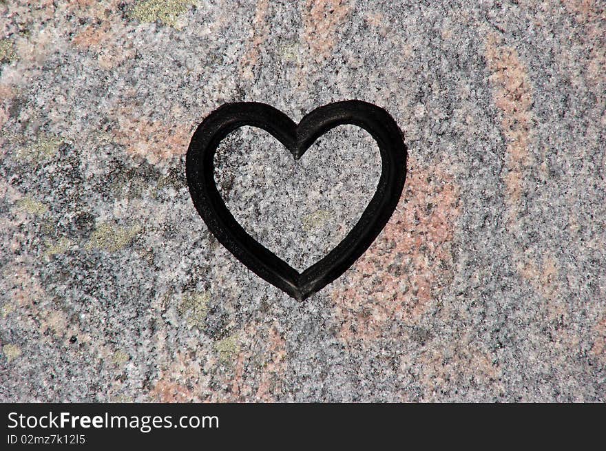 Black heart shape in a background of stone. Black heart shape in a background of stone