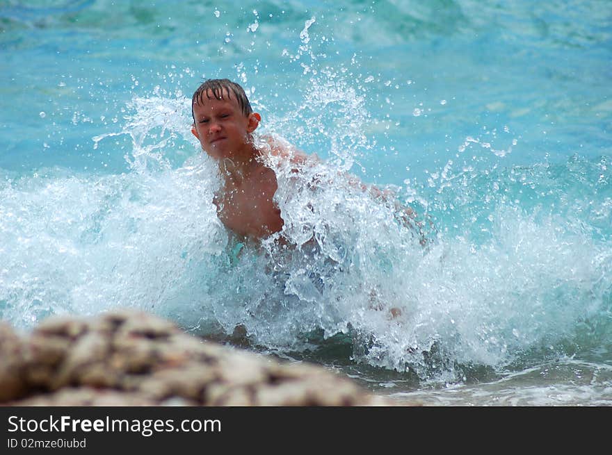 A boy is having fun in Adriatic water on Hvar island, Croatia