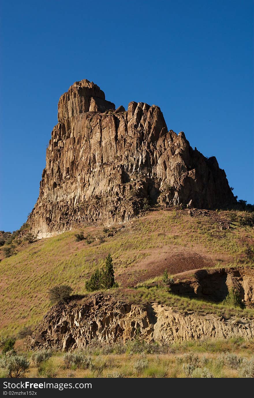 A magnificent outcropping of basalt stands against the blue sky in the eastern Oregon desert. A magnificent outcropping of basalt stands against the blue sky in the eastern Oregon desert