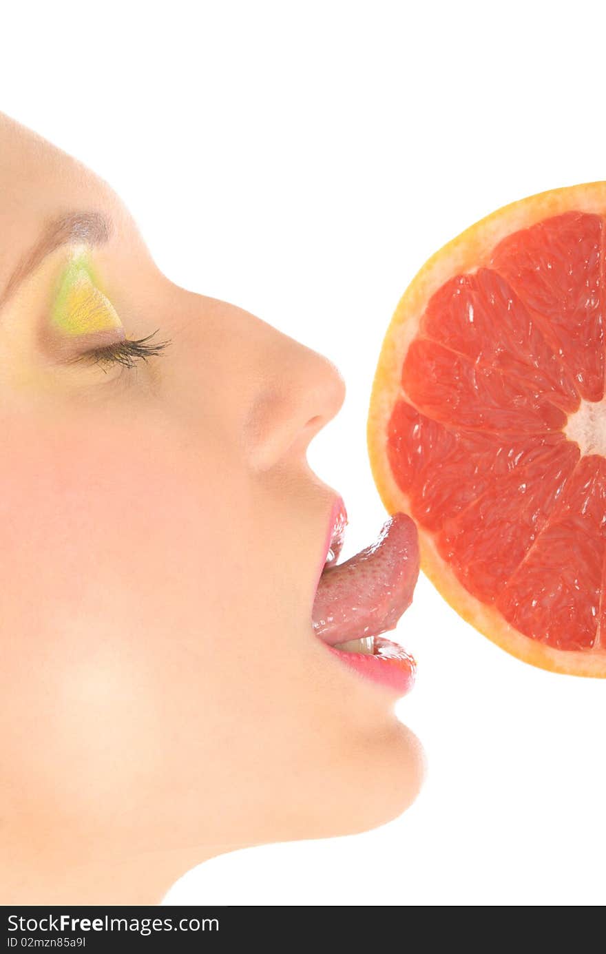 Woman with make-up licks grapefruit