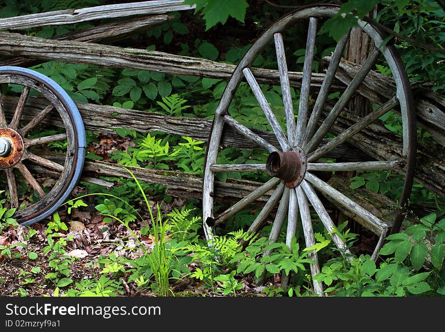 Old wagon wheels laying against an old cedar fence