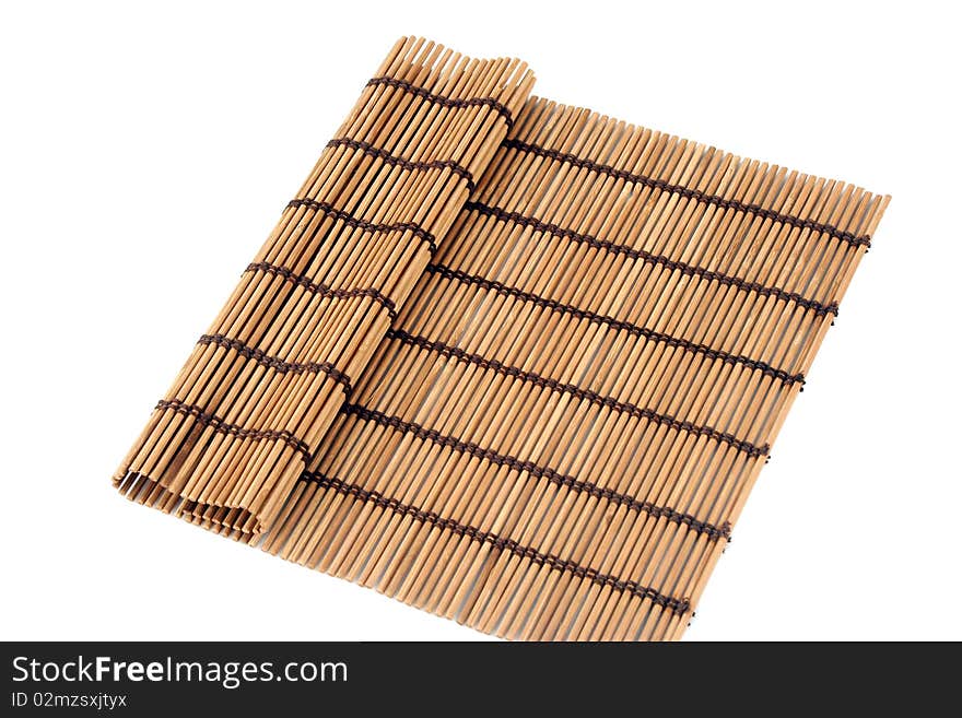 Rolled bamboo mat and a pair of chopsticks inside it isolated on white background. Rolled bamboo mat and a pair of chopsticks inside it isolated on white background