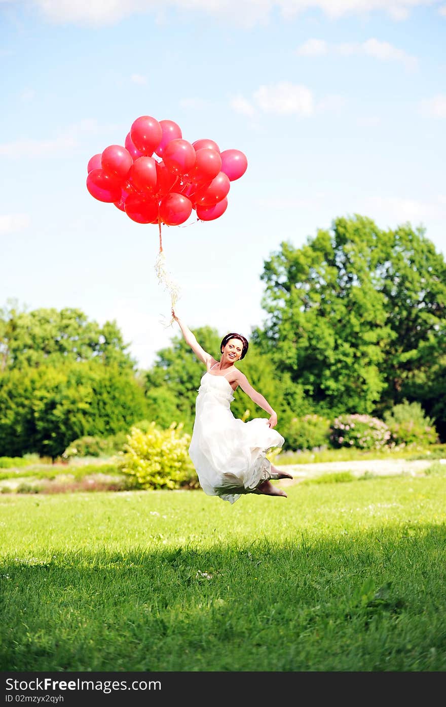 Bride in  white dress with balloons  on  green field. Bride in  white dress with balloons  on  green field