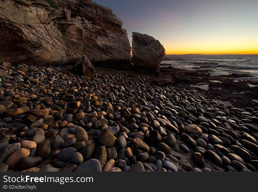 Image of pebbles on a beach take at sunrise on the South African coast line. Image of pebbles on a beach take at sunrise on the South African coast line