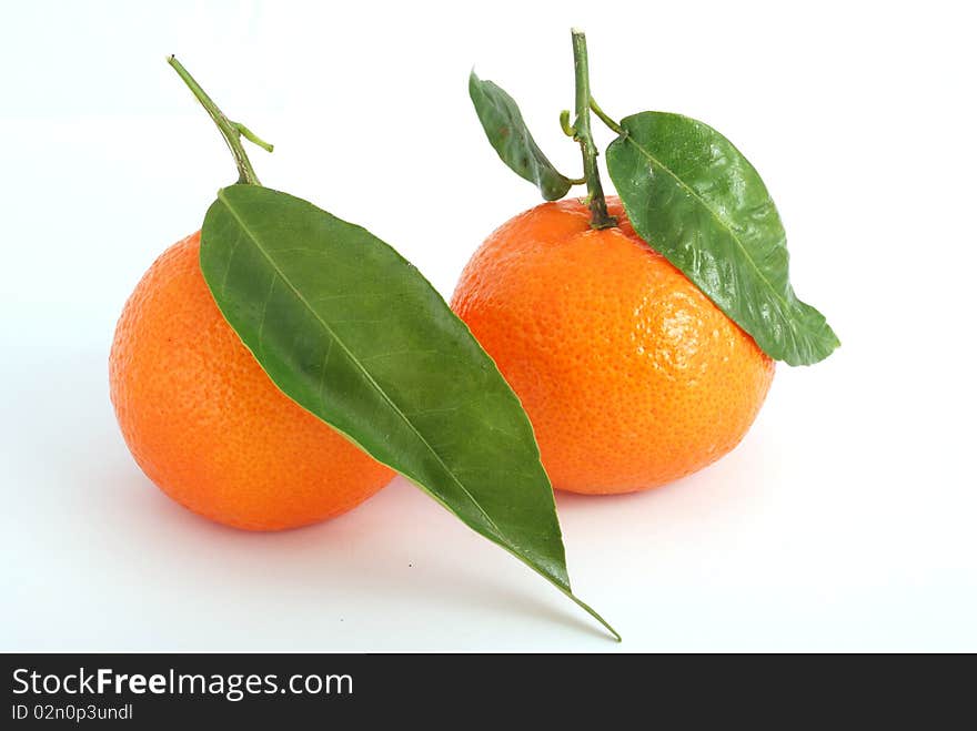 Tangerine with green leaves and water drops isolated on white