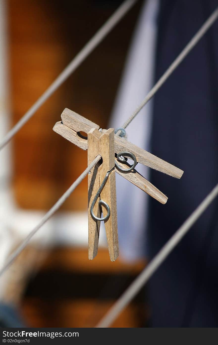 Two wooden clothespins on a clothing line, close up