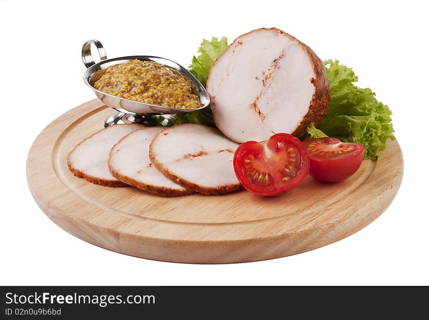 Sliced ham with mustard and vegetables on a wooden plate isolated