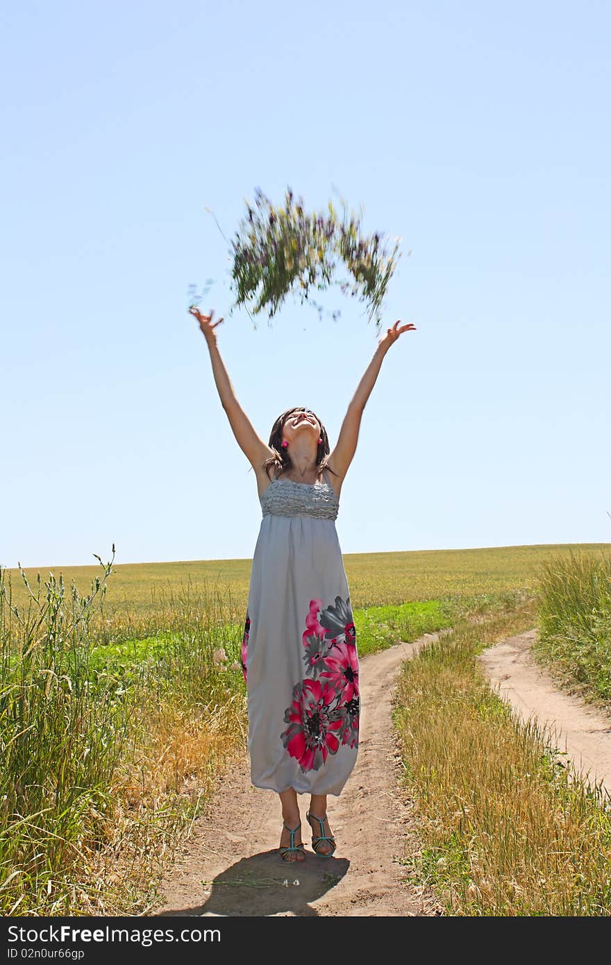 The young girl throws upwards a bunch of flowers