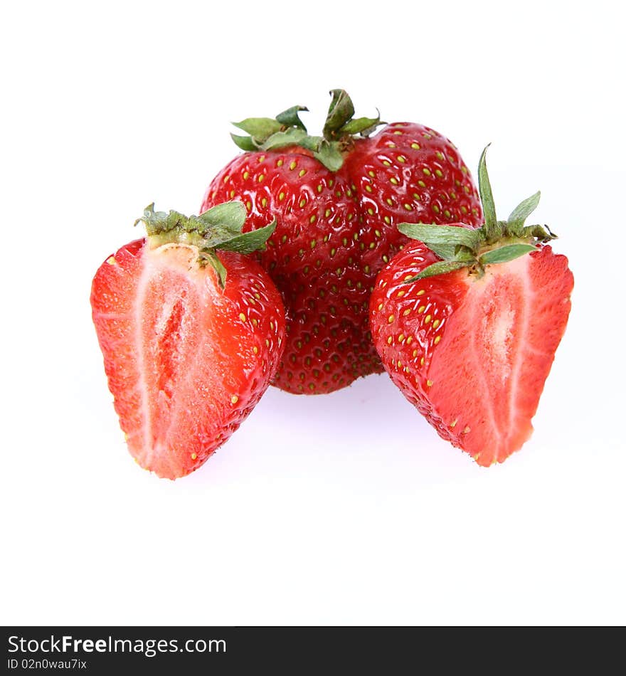 Strawberries on white background (a whole one and two halves)