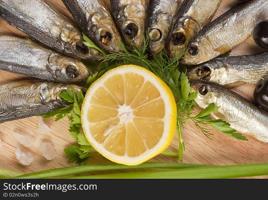 A composition with smoked clupea herring fish (Clupea harengus membras) on wooden plate isolated on white. A composition with smoked clupea herring fish (Clupea harengus membras) on wooden plate isolated on white