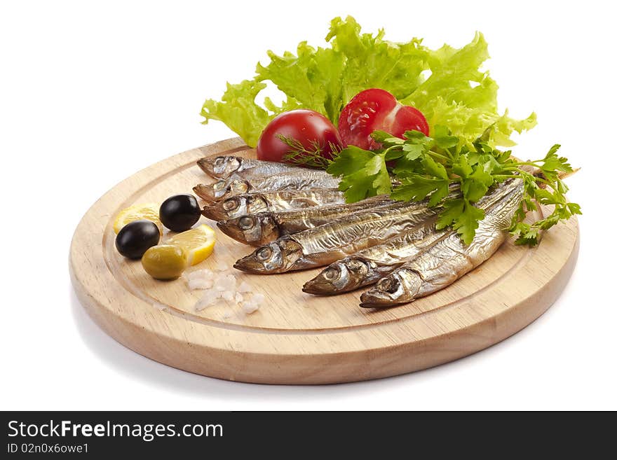 A composition with smoked clupea herring fish (Clupea harengus membras) on wooden plate isolated on white. A composition with smoked clupea herring fish (Clupea harengus membras) on wooden plate isolated on white