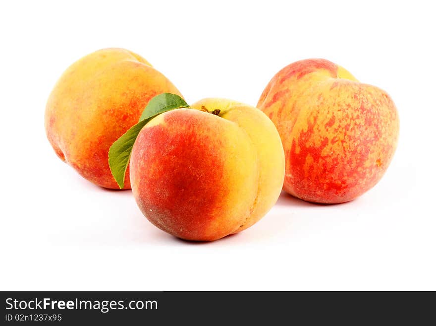 Ripe peaches with leaf isolated on a white background. Ripe peaches with leaf isolated on a white background