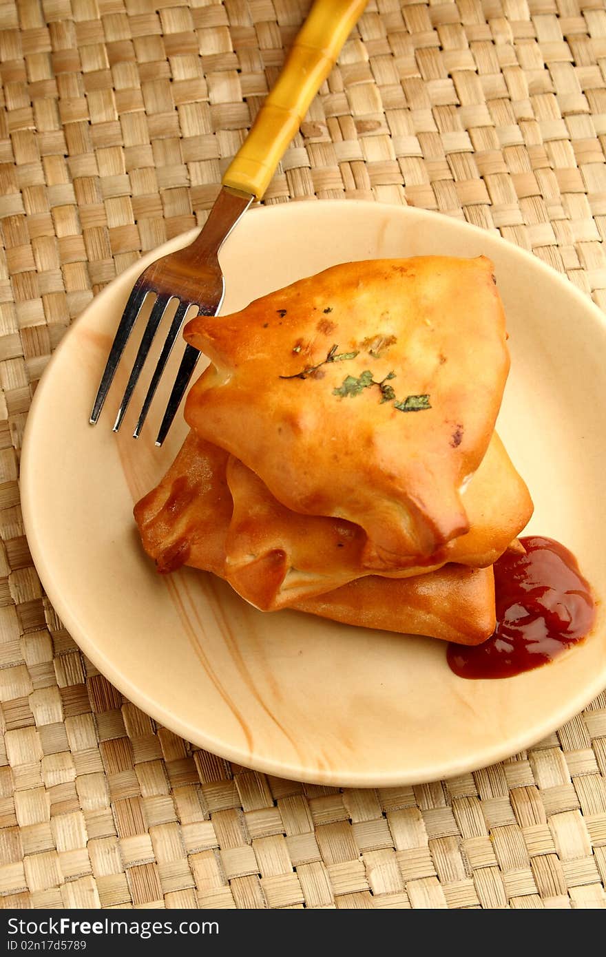 Vegetable  puff with tomato ketchup on a mat background. Vegetable  puff with tomato ketchup on a mat background