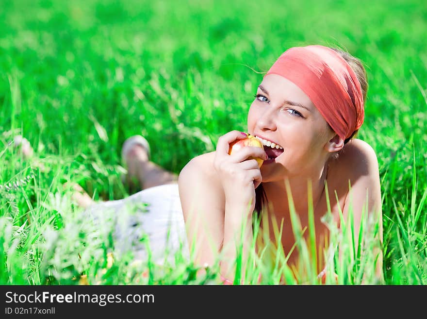 Girl with apple on grass