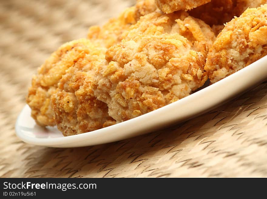 Coconut cookies in a white plate on mat background