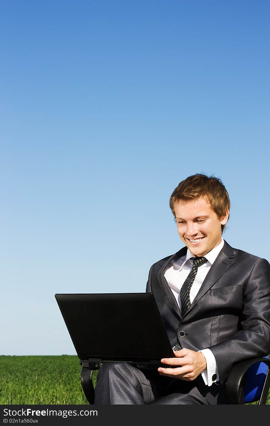 Businessman in the field, with a laptop. Happy, successful. Businessman in the field, with a laptop. Happy, successful