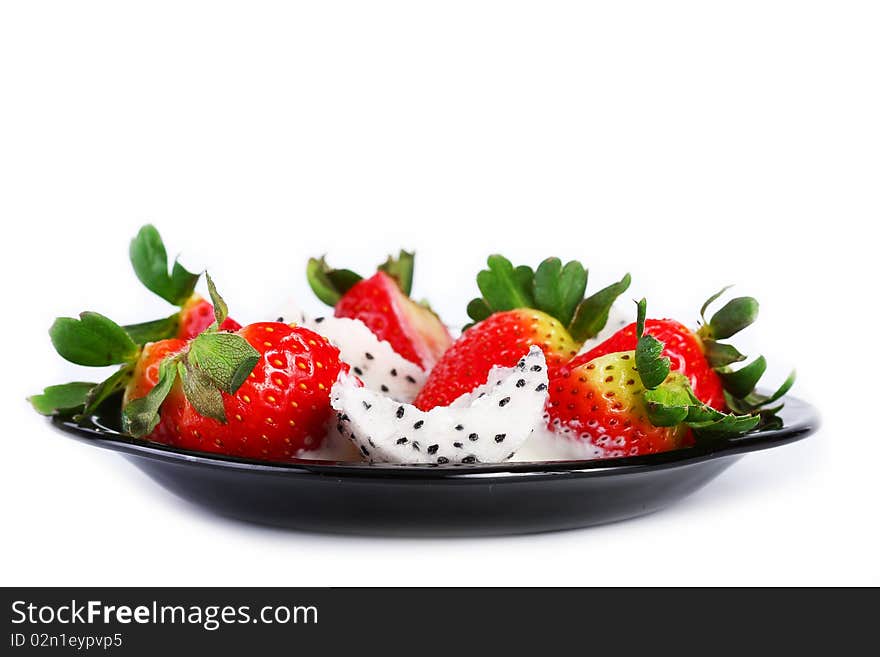 Pitahaya strawberries and cream on a black plate