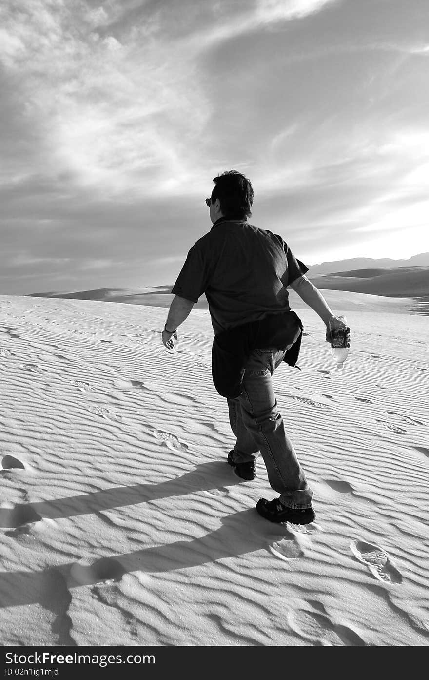 Man Hiking Up Dune