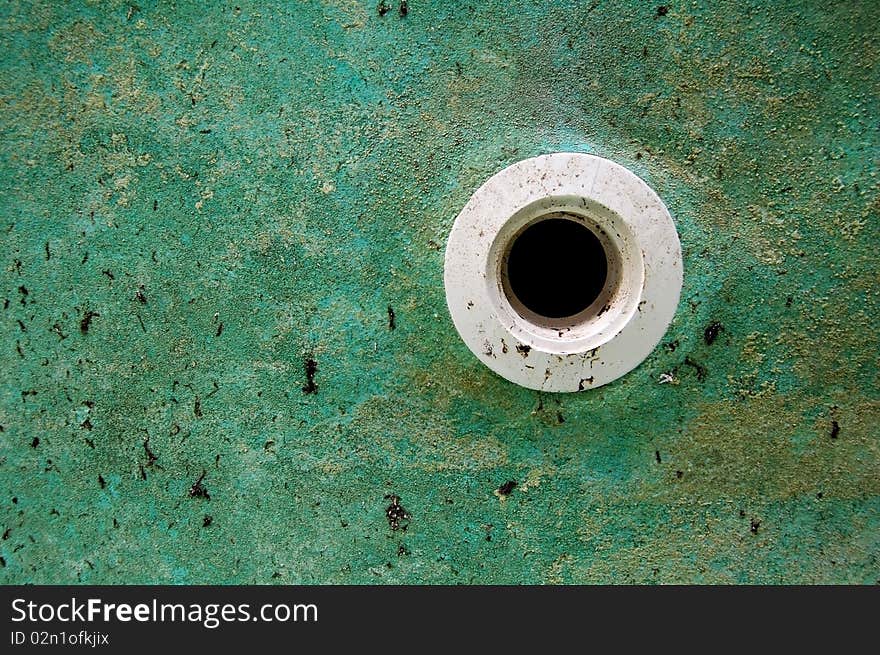 Grunge image of PVC pipe in a green wall