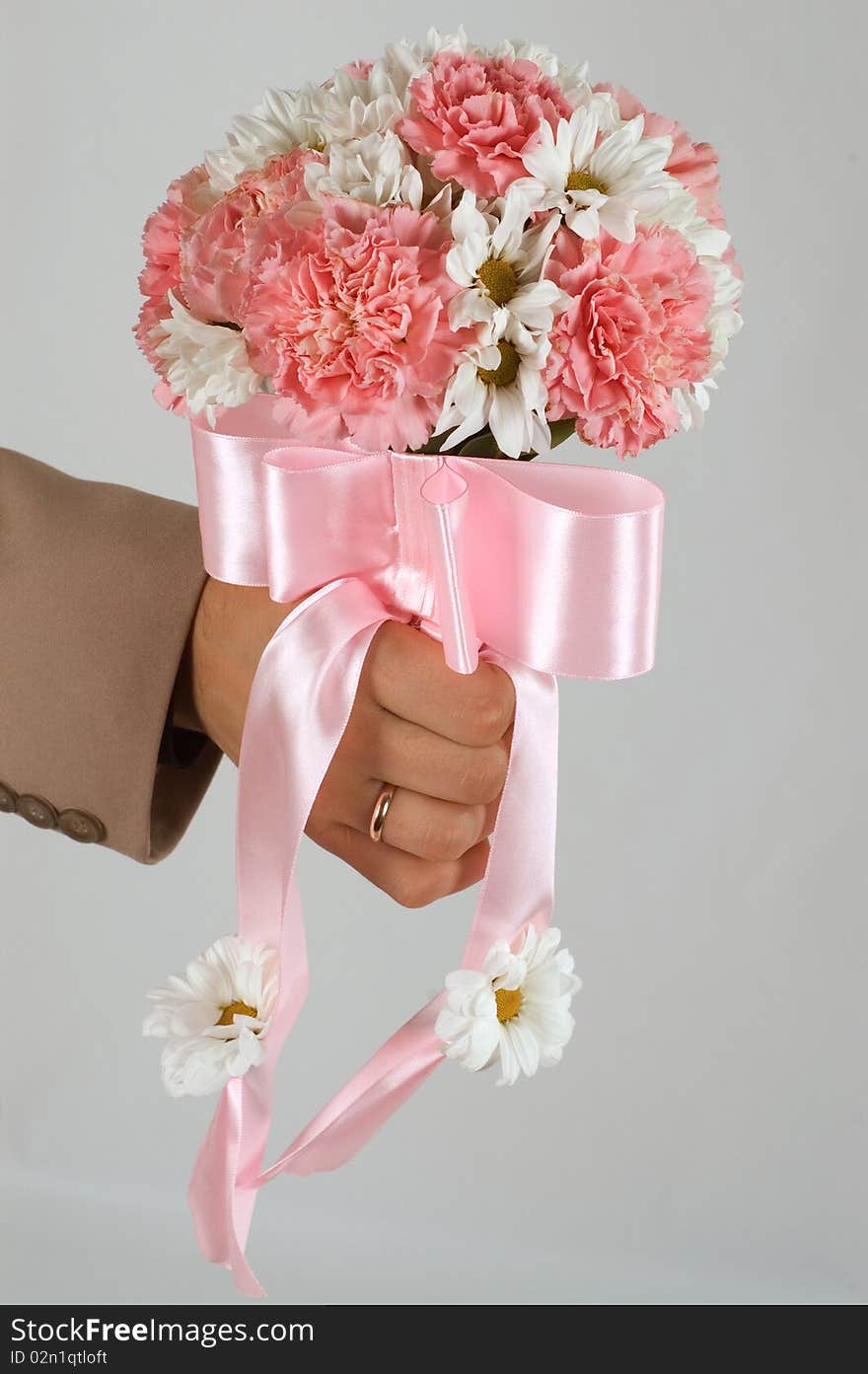 Groom holds flowers in his hand. Groom holds flowers in his hand