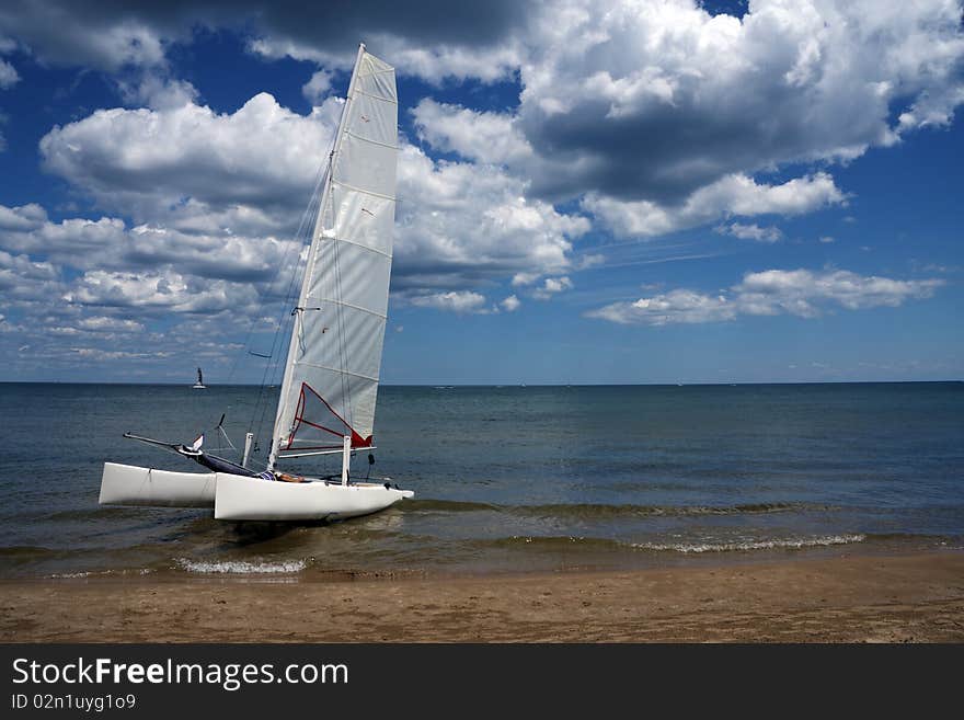 Boat in a lake ready to sail with blue sky and white clouds