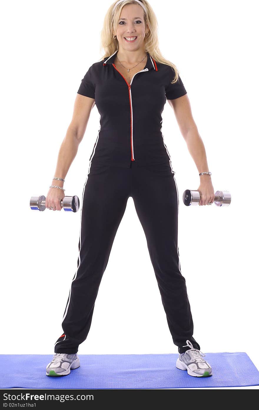 Woman lifting weights on floor mat