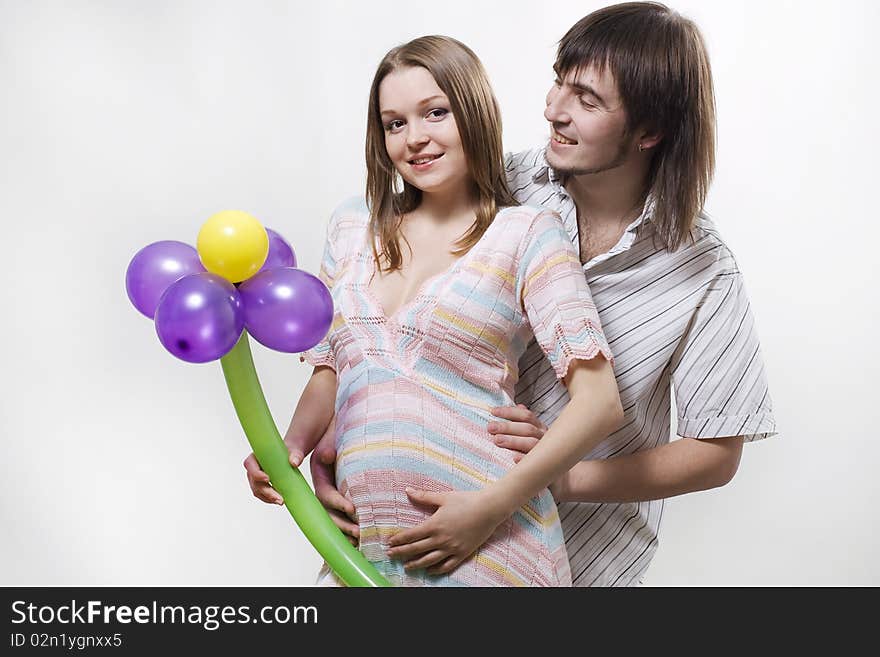 Happy flying pregnant couple holding balloon. Happy flying pregnant couple holding balloon